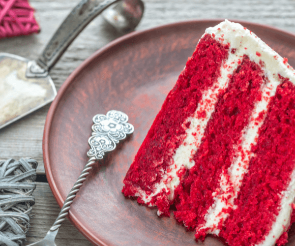 Vegan red velvet cake recipe on a plate with antique silverware 