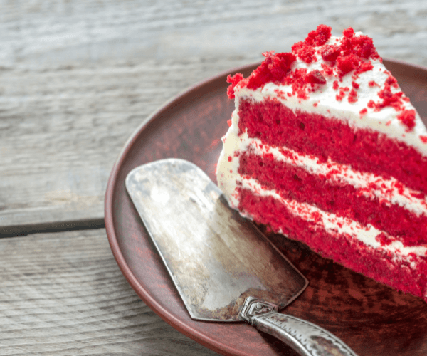 Vegan red velvet cake recipe on a plate with antique cake spatula