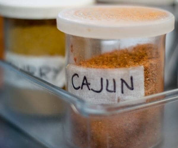 Cajun Seasoning in a clear jar with a white lid and tape labeled cajun 