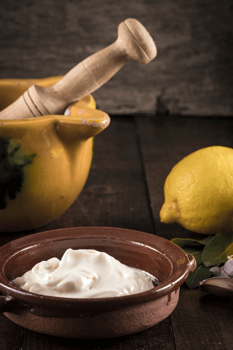 Vegan Mayo recipe next to a mortar and pestle with lemon. 
