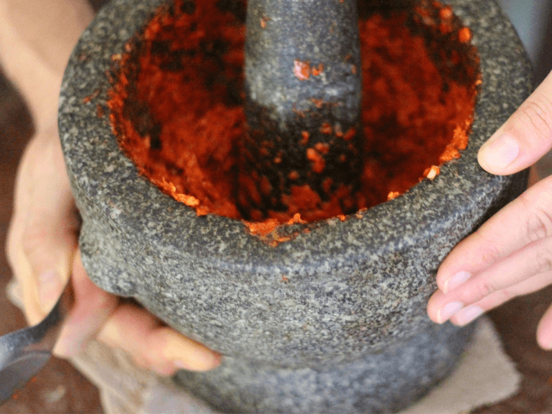 Using a mortar and pestle to make thai red curry paste